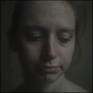 A face showing quiet melancholy — downcast eyes, slightly dr