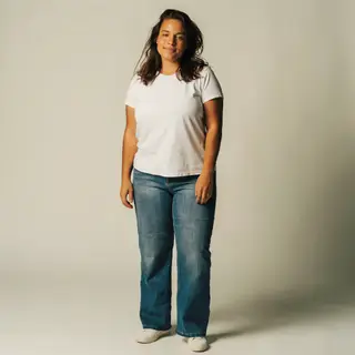 A woman standing upright in a relaxed pose, arms at her side