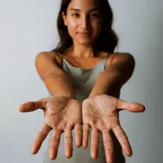 A woman holding her hands out in front of her palms-up, all 