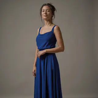 A woman wearing a royal blue evening dress against a neutral
