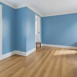 A room with walls in #4A90D9 (medium blue) with warm wooden 