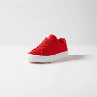 A single red sneaker on a clean white background with soft s