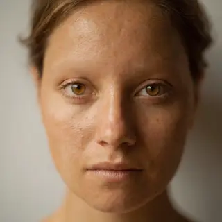 A human face with eyes, nose, and mouth but no eyebrows