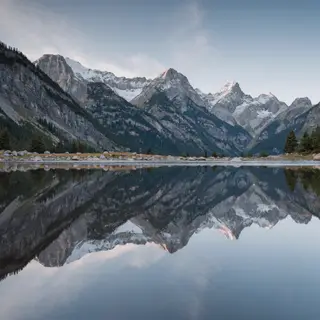 A mountain range reflected in a still alpine lake, with the 