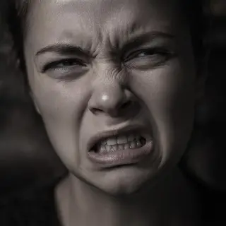 A close-up of a person's face showing clear disgust, nose wr