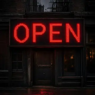 The word 'OPEN' displayed on a red LED sign with glowing pix