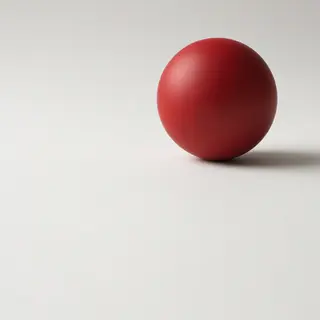 A red sphere on a white surface with a single shadow cast to
