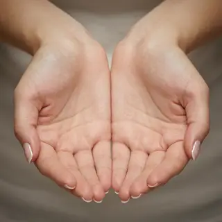 A woman holding her hands out in front of her palms-up, all 