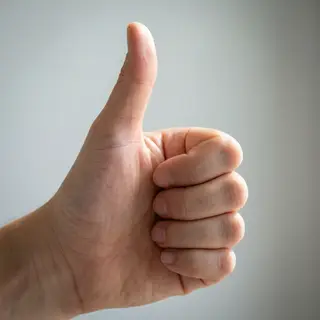 A hand giving a thumbs-up with four fingers curled and thumb