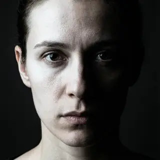A portrait with dramatic split lighting — half the face brig