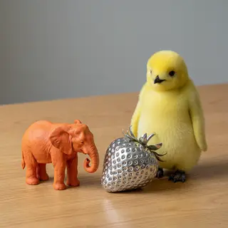 An orange elephant, a yellow penguin, and a silver strawberr