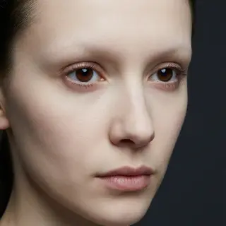 A human face with eyes, nose, and mouth but no eyebrows