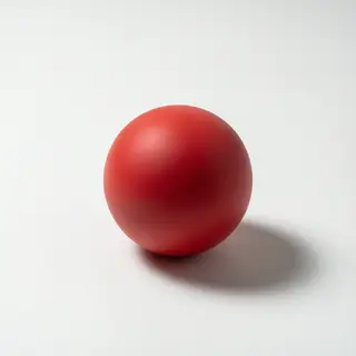 A red sphere on a white surface with a single shadow cast to