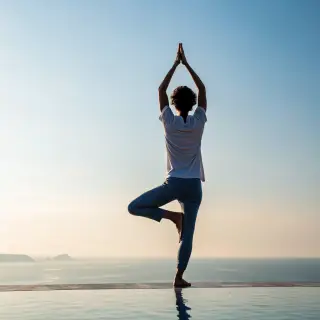 A person in a yoga tree pose — standing on one leg with the 