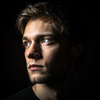 A portrait with dramatic split lighting — half the face brig