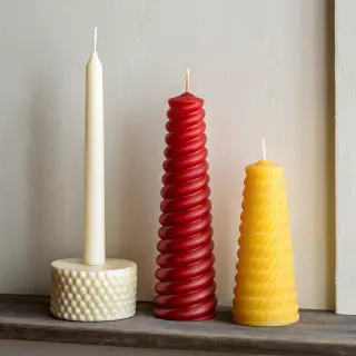 A tall thin white candle, a short fat red candle, and a medi