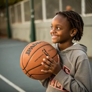 A child holding a basketball, both at correct relative sizes