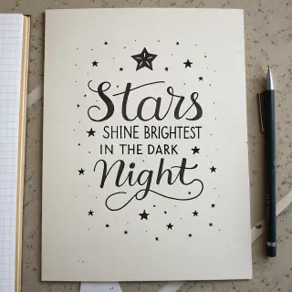'Stars shine brightest in the dark night' displayed on a cle