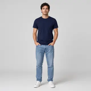A man standing straight facing the camera, hands in pockets,
