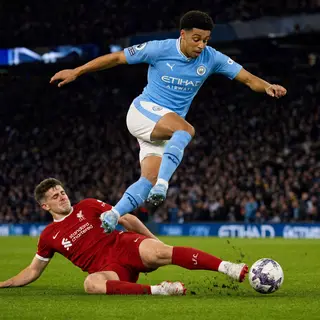 Two soccer players mid-tackle, one sliding and the other jum
