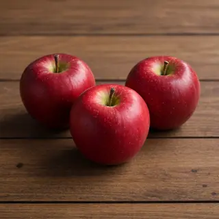 Exactly 3 red apples arranged on a wooden table