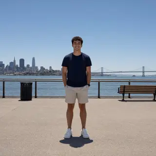 A person standing outdoors at midday with a short shadow dir