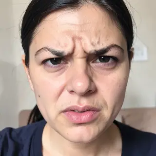 A close-up of a person's face showing clear disgust, nose wr