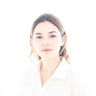 A high-key portrait of a person against a bright white backg