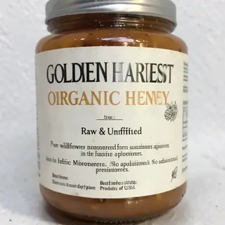 A product label for 'GOLDEN HARVEST ORGANIC HONEY' with subt