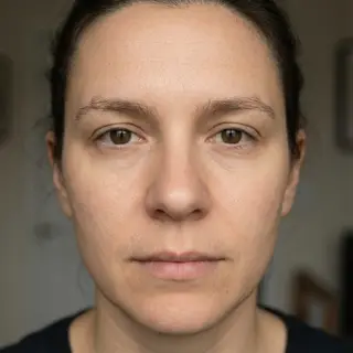 A human face with eyes, nose, and mouth but no eyebrows
