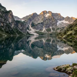 A mountain range reflected in a still alpine lake, with the 