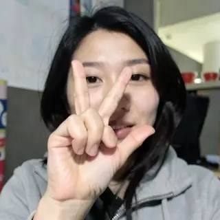 A person making a peace sign with their right hand, clearly 