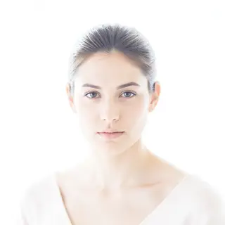 A high-key portrait of a person against a bright white backg