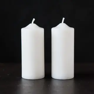Exactly 4 white candles standing on a dark surface