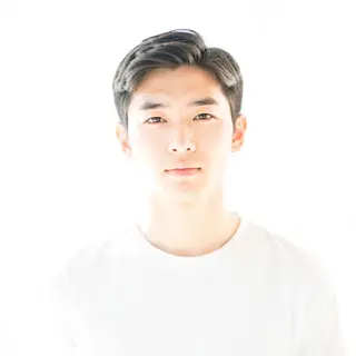 A high-key portrait of a person against a bright white backg