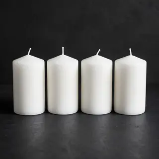Exactly 4 white candles standing on a dark surface