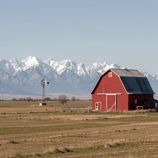 A landscape with a red barn in the foreground at large scale