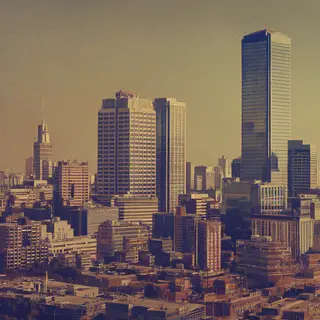 A cityscape rendered in nostalgic futurism — retro-futuristi