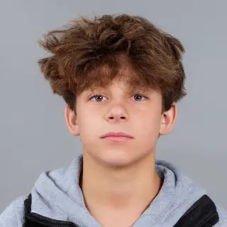 A headshot of a teenager with a relaxed, neutral face