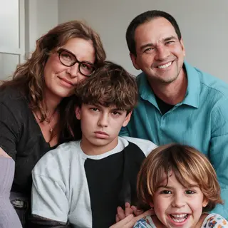 A family photo with four people: a father beaming with pride