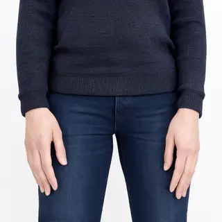 A person standing with both hands visible at their sides, fi