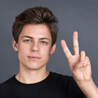 A person making a peace sign with their right hand, clearly 