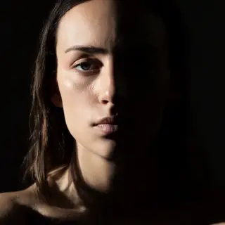 A portrait with dramatic split lighting — half the face brig