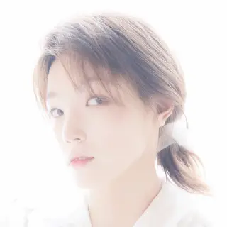 A high-key portrait of a person against a bright white backg