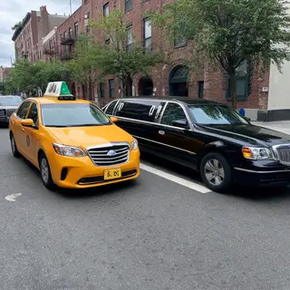 A yellow taxi and a black limousine parked next to each othe