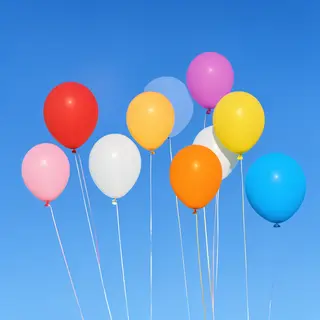 Exactly 11 colorful balloons floating against a clear blue s