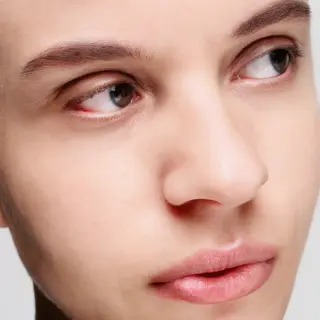A human face with eyes, nose, and mouth but no eyebrows