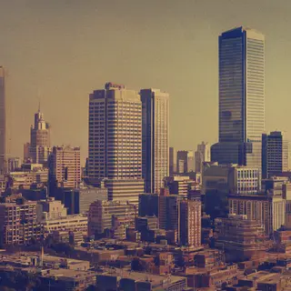 A cityscape rendered in nostalgic futurism — retro-futuristi