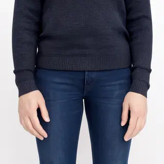 A person standing with both hands visible at their sides, fi