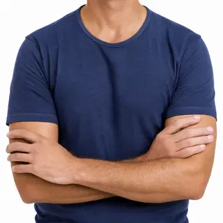 A man with arms crossed, both hands resting on opposite uppe
